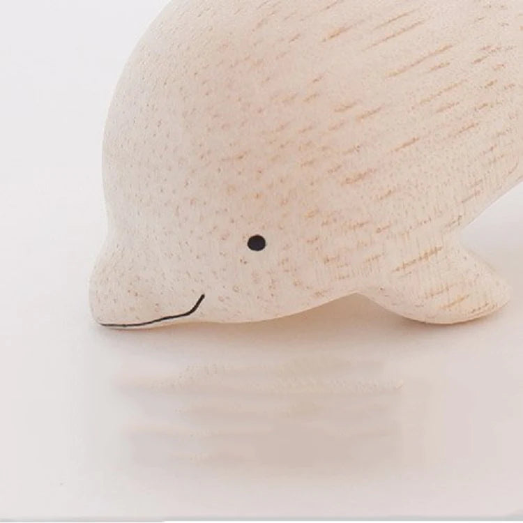 A close-up image of a handmade tiny wooden dolphin figurine, hand-carved from eco-responsible forests, with a smooth texture and a minimalistic design, featuring a small smile.