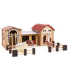 The Wooden Farmyard Stables set includes two buildings with red roofs, a fenced yard, two horses with brown and white markings, a ladder, animal shelters, and painted details for realistic farm play.