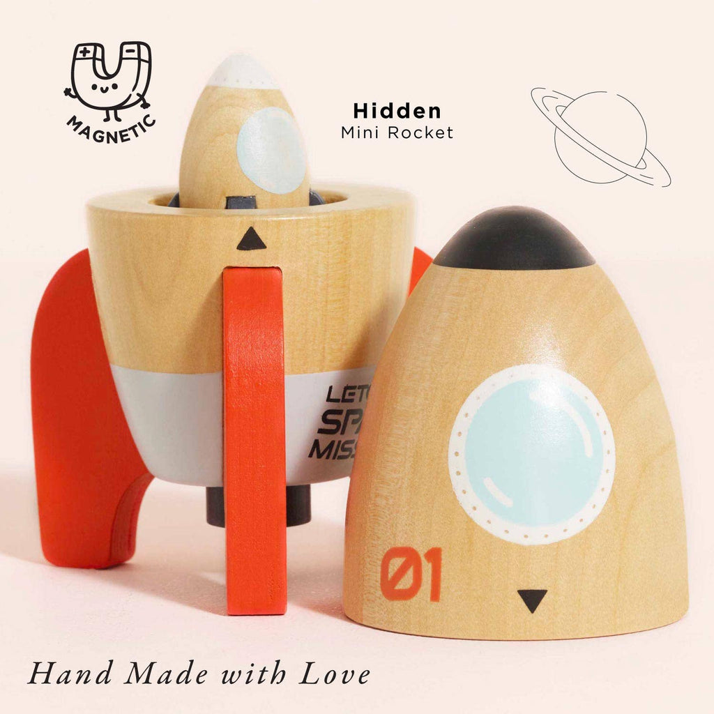 The Magnetic Space Rocket Duo is a wooden toy rocket with red fins and a detachable nose cone that hides a mini magnetic rocket inside. Text includes "MAGNETIC," "Hidden Mini Rocket," and "Hand Made with Love," plus a planet for creative play.