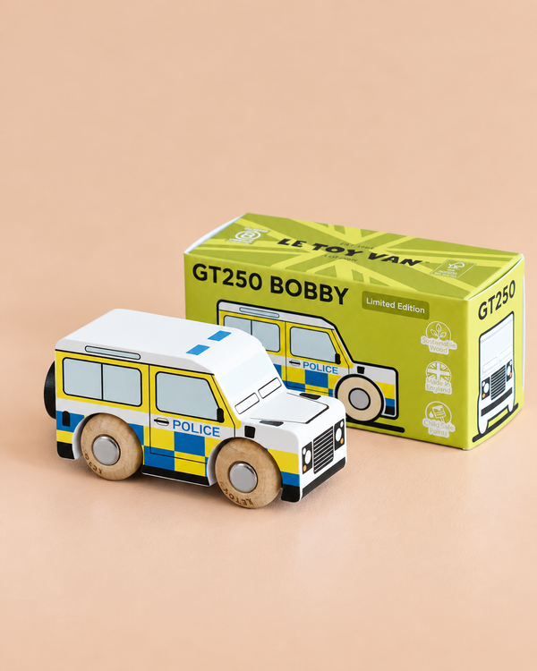 A wooden police van labeled “POLICE” sits beside its green box, which reads “No. 40 GT250 Bobby | Made in England” and displays an illustration of the van on the front—perfect for imaginative play inspired by a classic British patrol vehicle.