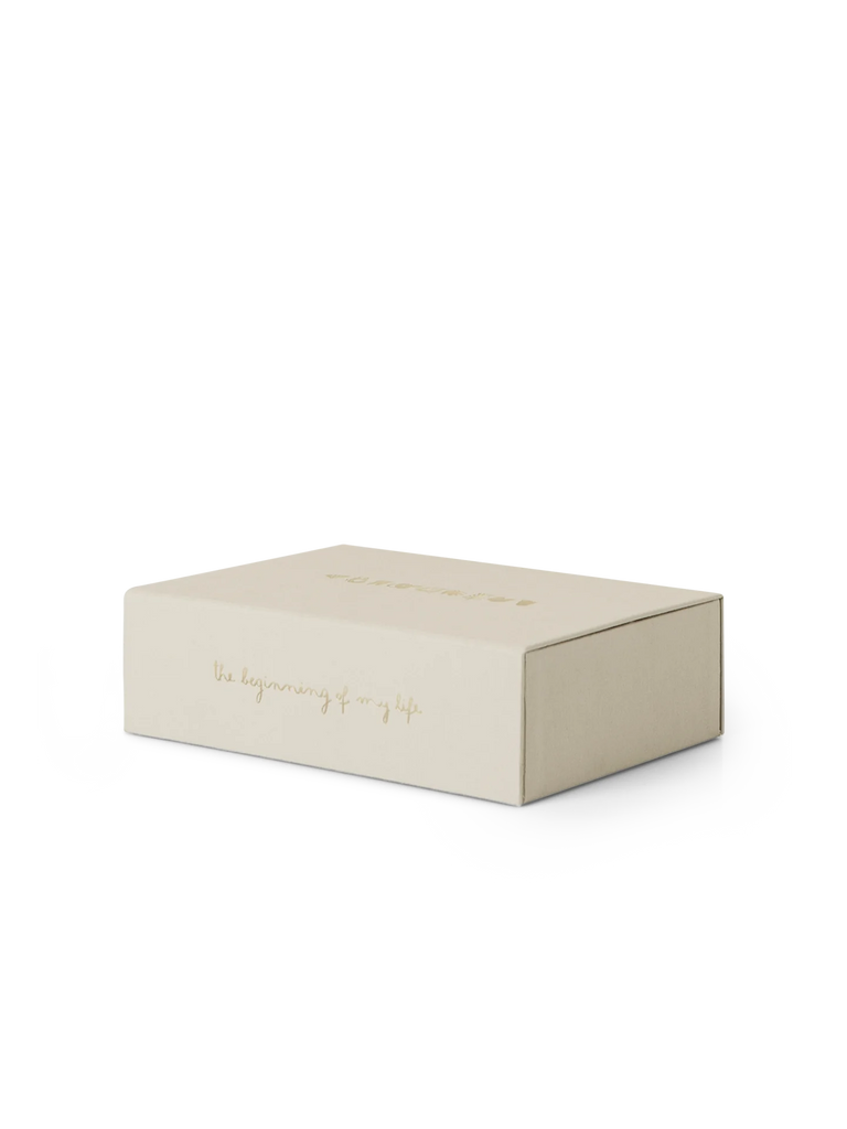 A beige, rectangular Kids Memory Box-The Beginning Of My Life with gold text on the lid that reads "The beginning of..." and partially visible text following. The box is closed and resting on a white surface, evoking a sense of cherished childhood memories.