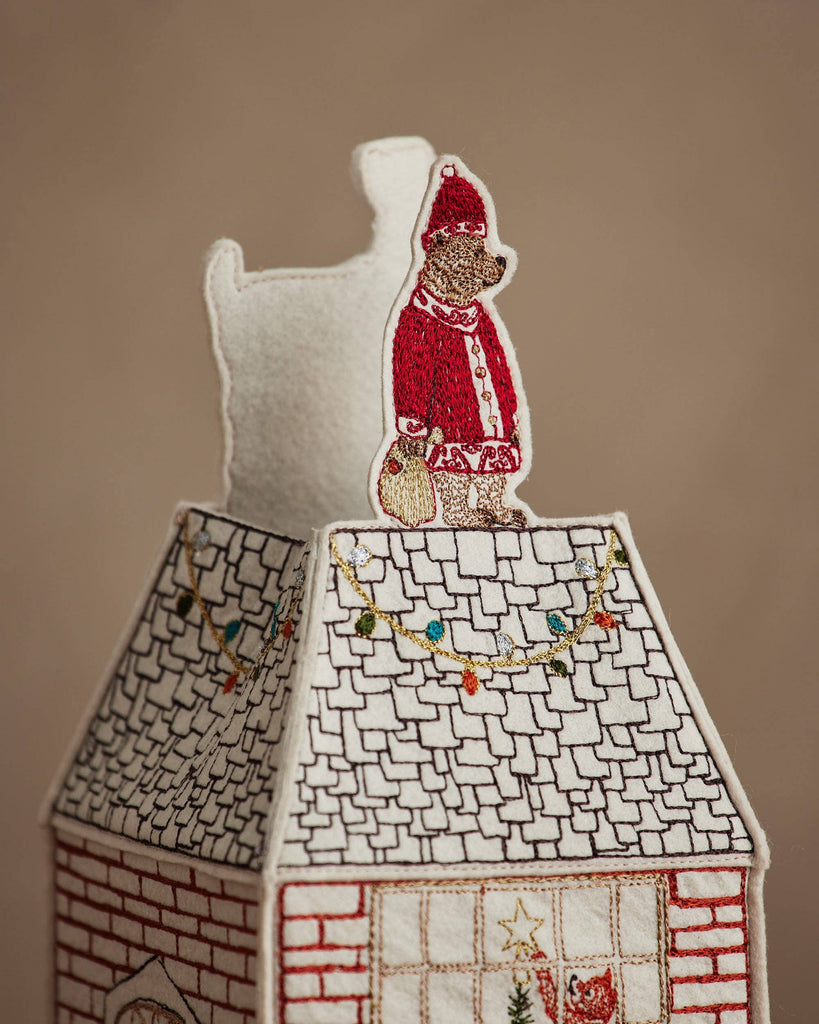 The Coral & Tusk Home for the Holidays Tissue Box Cover features an embroidered house with a bear Santa on the snowy roof, festive lights, and a sack—an adorable touch to enhance your seasonal decor.