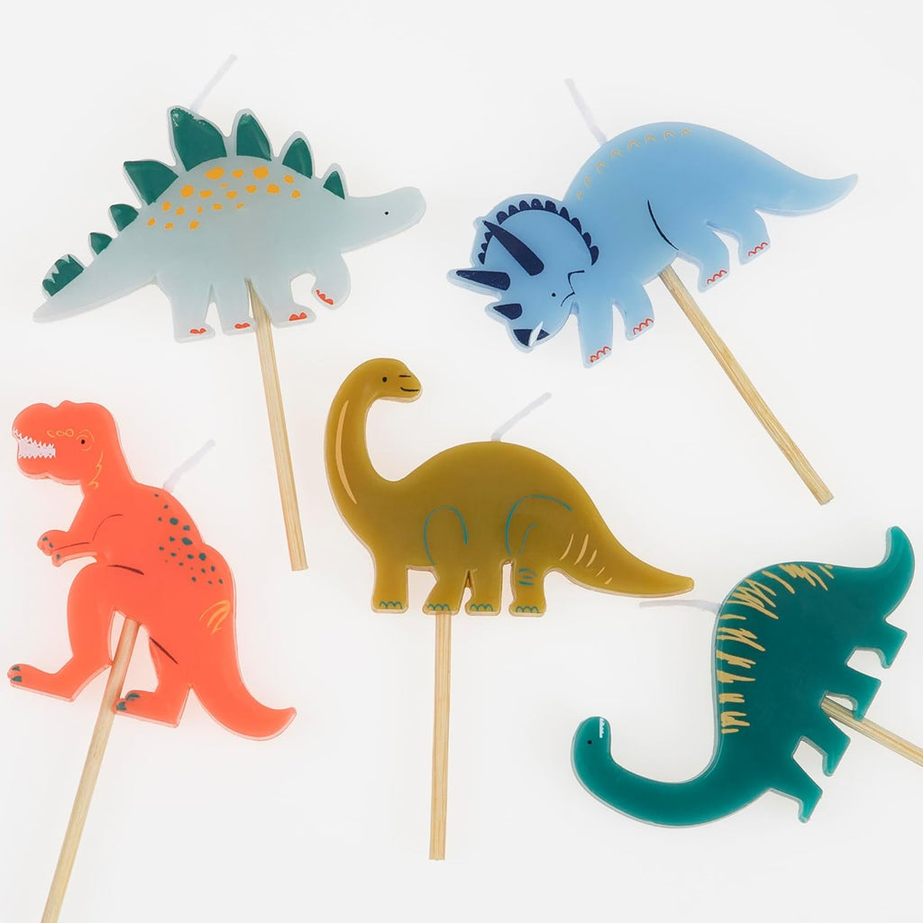 Five Meri Meri Dinosaur Candles with stick handles, displayed against a white background, featuring different dinosaur species in various colors.