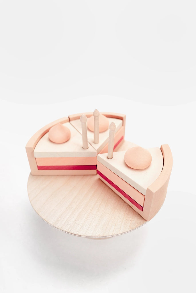 Handmade Strawberry Layer Cake On A Stand shaped like geometric figures on a circular base, coated with non-toxic paint, featured in a minimalist white setting.