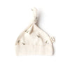 The Organic Baby Hat – Runner Ducks is a soft, cream newborn hat with a top knot and runner duck prints, made from GOTS-certified organic cotton. A side tag reads "Ollie." Shown flat on a white background.