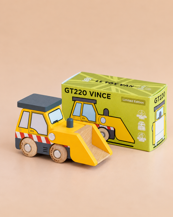 A yellow wooden toy bulldozer, named No. 38 GT220 Vince and made in England, sits in front of its green box labeled “GT220 VINCE.” Perfect for imaginative construction play, the box features an illustration of the bulldozer and notes it as a “Limited Edition.”.