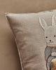 The Coral & Tusk Easter Bunny Pocket Pillow features a beige design with an embroidered white bunny in a blue outfit on a neutral background—an adorable and festive decoration for Easter.
