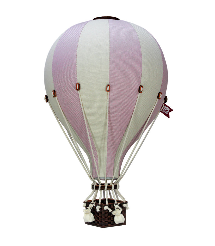 The Hot Air Balloon - Lilac features alternating lilac and white panels, brown trim, ropes, a small woven basket, and a charming flag. This handmade decor is perfect for adding whimsy to any children's room.