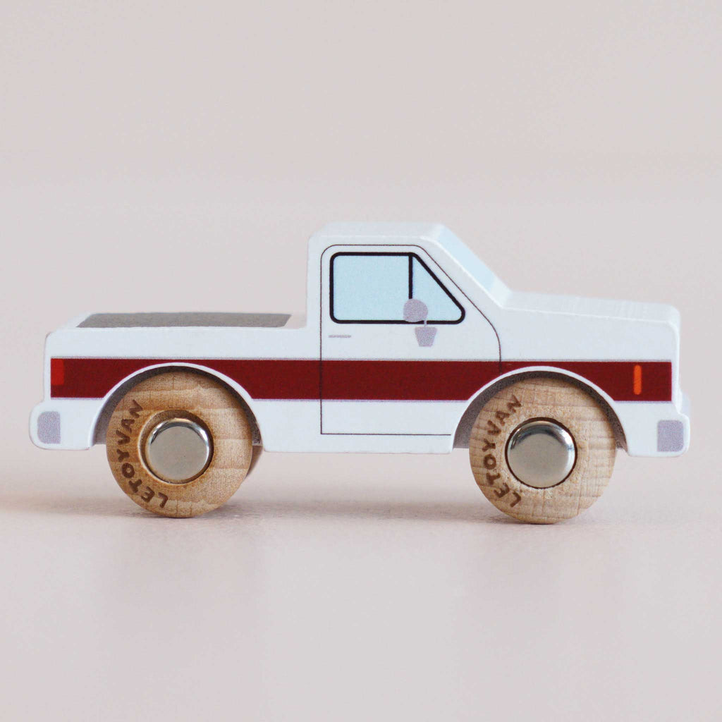 Introducing the No. 30 GT165 Charlie, a classic wooden pick-up truck made in England, featuring a striking white body with a bold red stripe and natural wooden wheels—shown from the side against a plain background.