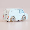 Introducing the No. 32 GT175 Frank, made in England—a classic wooden toy van with a minimalistic design. This small white vehicle showcases simple black and blue line details and wooden wheels, making it perfect for inspiring imaginative play on a light pink surface.
