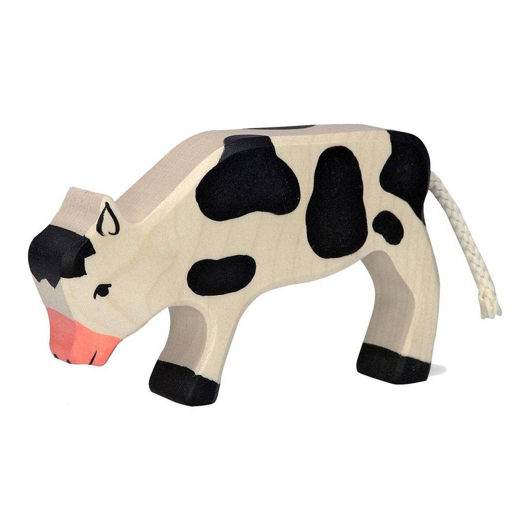 The Holztiger Calf, Grazing is a handcrafted wooden toy featuring painted black spots, a pink snout, and a braided white rope tail. Standing on four legs, it is made in Europe.