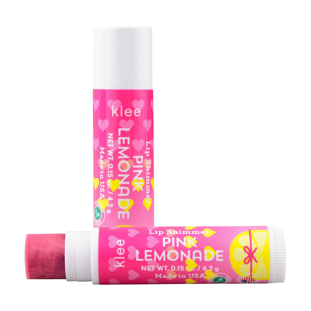 Two Klee Naturals Deluxe Makeup Kit - Regal Queen Fairy pink lemonade lip shimmer tubes with pink heart patterns, one standing upright and one lying horizontally with the cap removed to show the pink product.