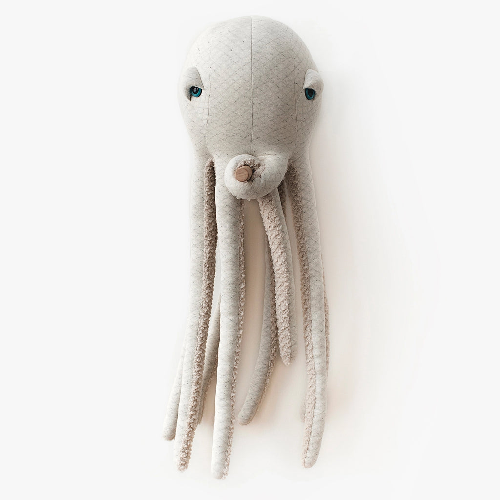 A white, plush BigStuffed Octopus - Big Albino is shown against a plain white background. This adorable octopus plush has a round head with two small, blue eyes and several long, textured tentacles. It appears soft and cuddly, suitable for children or as a decorative piece in an underwater world-themed room.