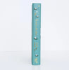 The image shows the teal spine of "The Wind in the Willows" by Kenneth Grahame, a Collector's Edition hardcover with gold water lily and reed illustrations for an elegant touch.