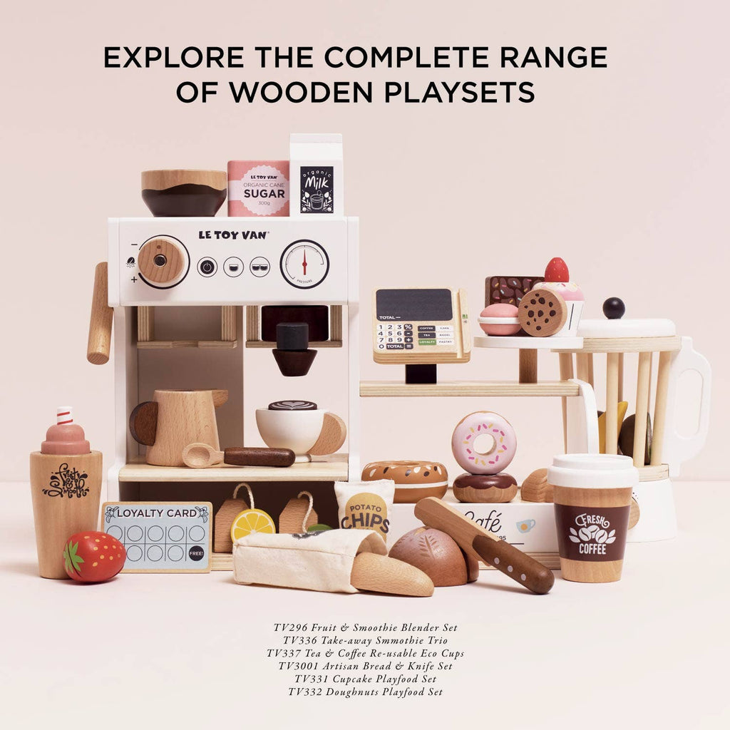The Barista Café Shop wooden playset, featuring a coffee machine, blender, cash register, play food, and drinks, is displayed on a light background. Text above: "Explore the complete range of wooden playsets." Ships in one week.