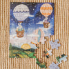 A partially completed Sky High Friends 40 Piece Mini puzzle, featuring whimsical animals in hot air balloons floating over a sunrise landscape, lies on a textured carpet with a few loose pieces beside it.