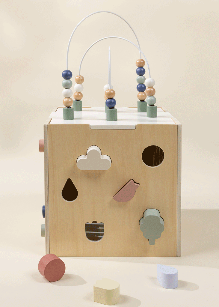 The Wooden Activity Cube features bead mazes on top and shape-sorting cutouts for clouds, birds, and trees, helping toddlers build fine motor skills. Brightly colored blocks are included for extra fun.