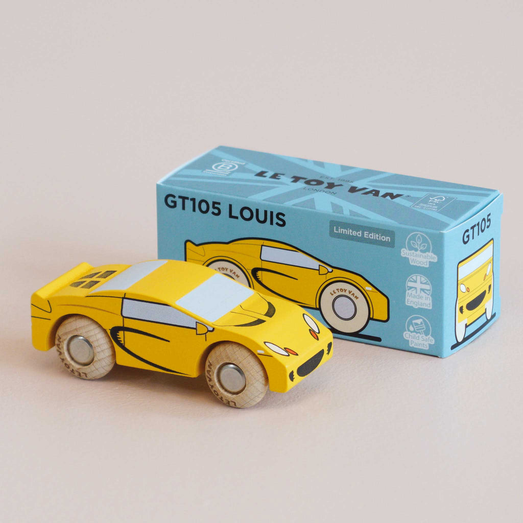 A yellow wooden sports car sits beside its blue box labeled “No. 19 GT105 Louis | Made in England.” The box features an illustration of the classic toy car and text indicating it is a limited edition by Le Toy Van.