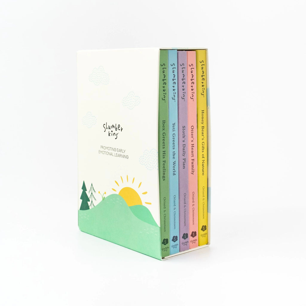 A set of four colorful children's books titled "Slumberkins A Lesson in Caring Board Book Set," designed to teach lessons in caring, presented in a decorated box showcasing a sun and hills design on a plain white background.