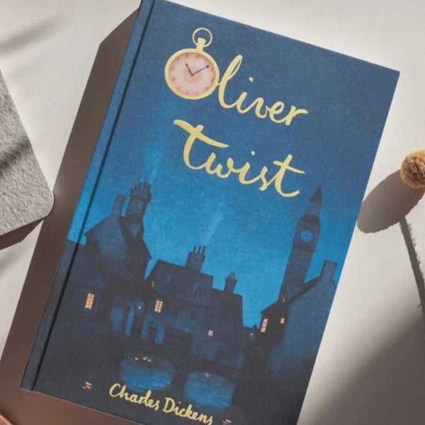 The blue hardcover "Oliver Twist | Dickens | Collector's Edition" features an illustrated nighttime cityscape with chimneys, a clock tower, and a pink pocket watch above the title.