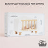 A white Wooden Dolls Cot inside its retail packaging box.