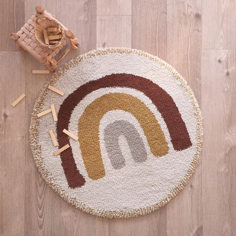 The Bohemian Rainbow Children's Rug - Final Sale, featuring brown, mustard yellow, and gray arches, brightens the light wood floor while a basket of wooden blocks spills across its charming surface.
