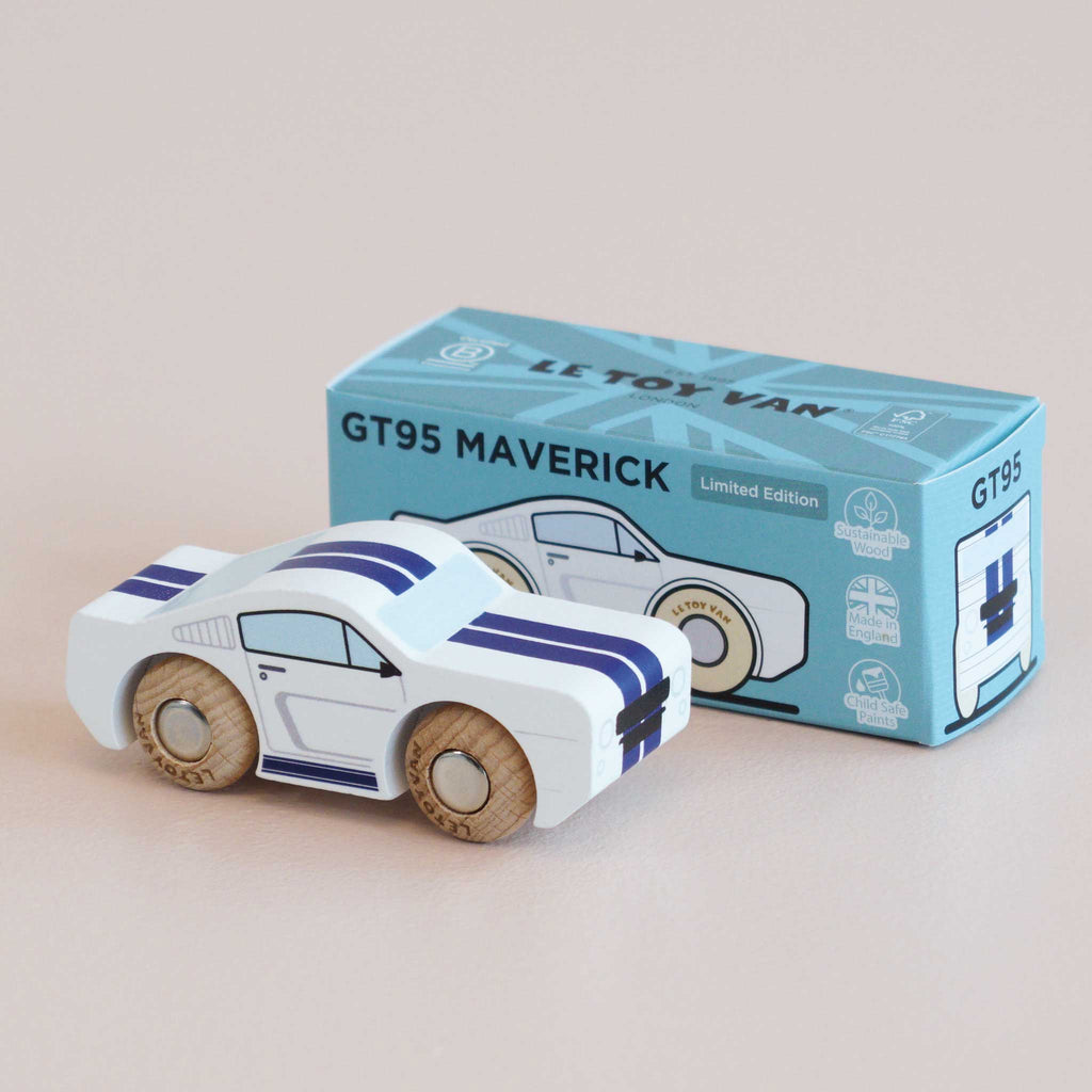 A white No. 17 GT95 Maverick toy car with blue racing stripes sits next to its matching blue box labeled “No. 17 GT95 Maverick | Made in England.” Inspired by a classic American muscle car, both the toy and the box share similar designs, and the car is finished with wooden wheels.