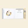 The Wishy Washy (Water Reveal Edition) is a perfect toddler travel activity, featuring a palette with paint colors, a notepad displaying “Wishy Washy Wishy Washy SWISH SWISH,” and a water brush pen.