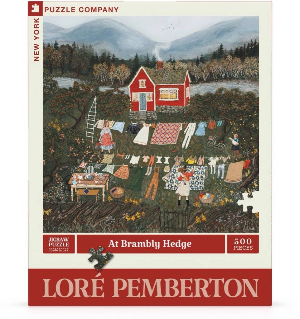 “At Brambly Hedge - 500 Piece Jigsaw Puzzle” features Loré Pemberton’s artwork of a red house, people tending laundry and a garden in a rural autumn scene, with a linen finish by New York Puzzle Company.