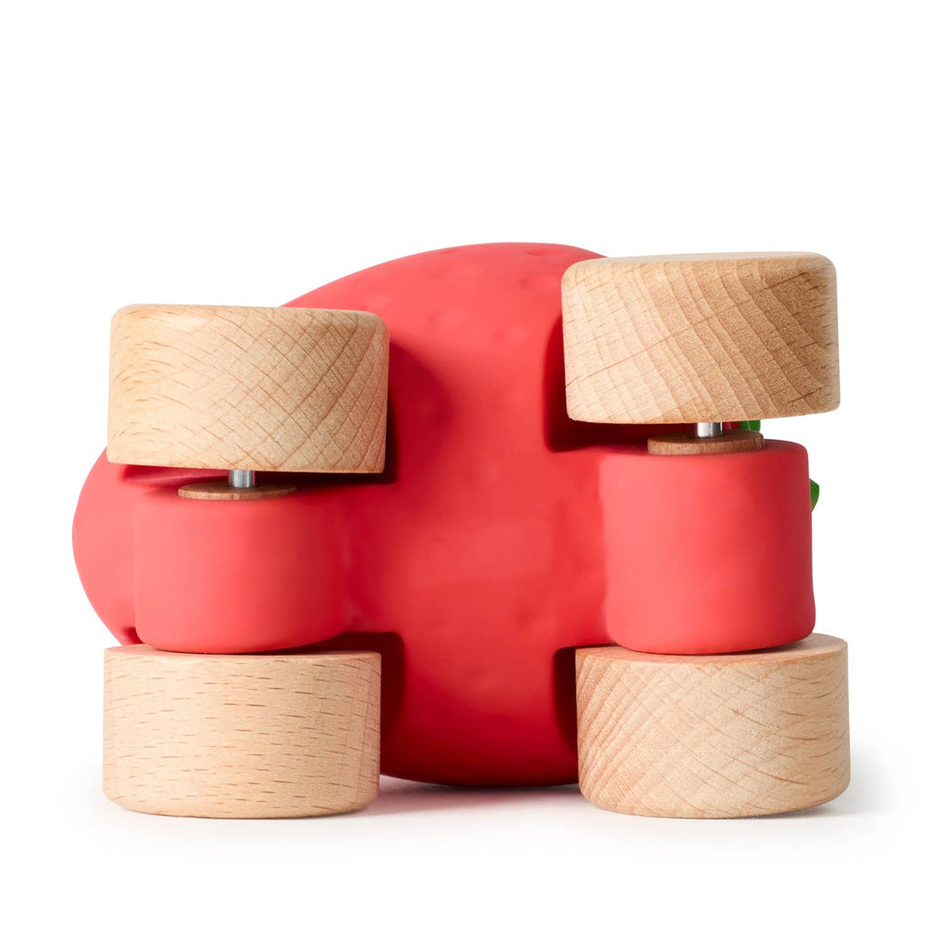 Sweetie The Strawberry Baby Car is a red, eco-friendly baby toy shaped like a strawberry with four light wooden wheels, shown from below against a white background.