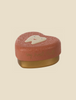 A charming heart-shaped Maileg Tooth Box with "my sweet tooth" written in gold on the side. The lid is a reddish-pink with a smiling tooth illustration, while the base is a contrasting pale yellowish-brown color, perfect for storing small baby teeth and preserving cherished childhood memories.