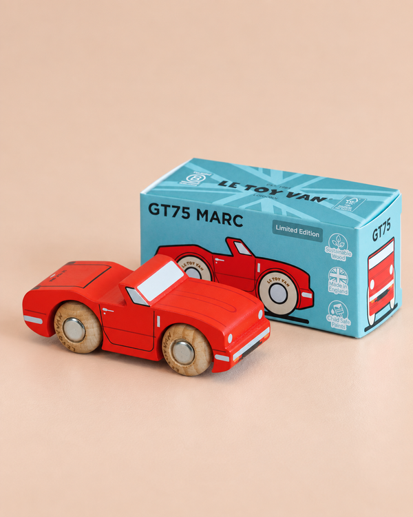 A vibrant red wooden convertible toy car with tan wheels sits in front of its blue box packaging labeled “No. 13 GT75 Marc | Made in England” and “Limited Edition,” which displays an illustration of this classic car.