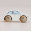 The No. 9 GT55 Betty, made in England, is a small classic wooden car featuring a white body, blue-tinted windows, and natural wood wheels that evoke the charm of a nostalgic toy—all beautifully presented against a soft beige background.