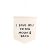 The I Love You To The Moon And Back Canvas Sign features a cream fabric hanging from a wooden rod with string, displaying “I LOVE YOU TO THE MOON & BACK” in bold, black hand-lettered text.