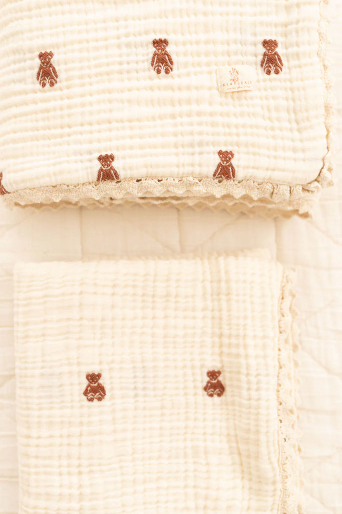 Two cream-colored, textured muslin baby blankets with brown teddy bear embroidery and scalloped lace edges—perfect as Organic Cotton Layered Gauze Baby Blanket - Teddy (ships in one week) for your little one.