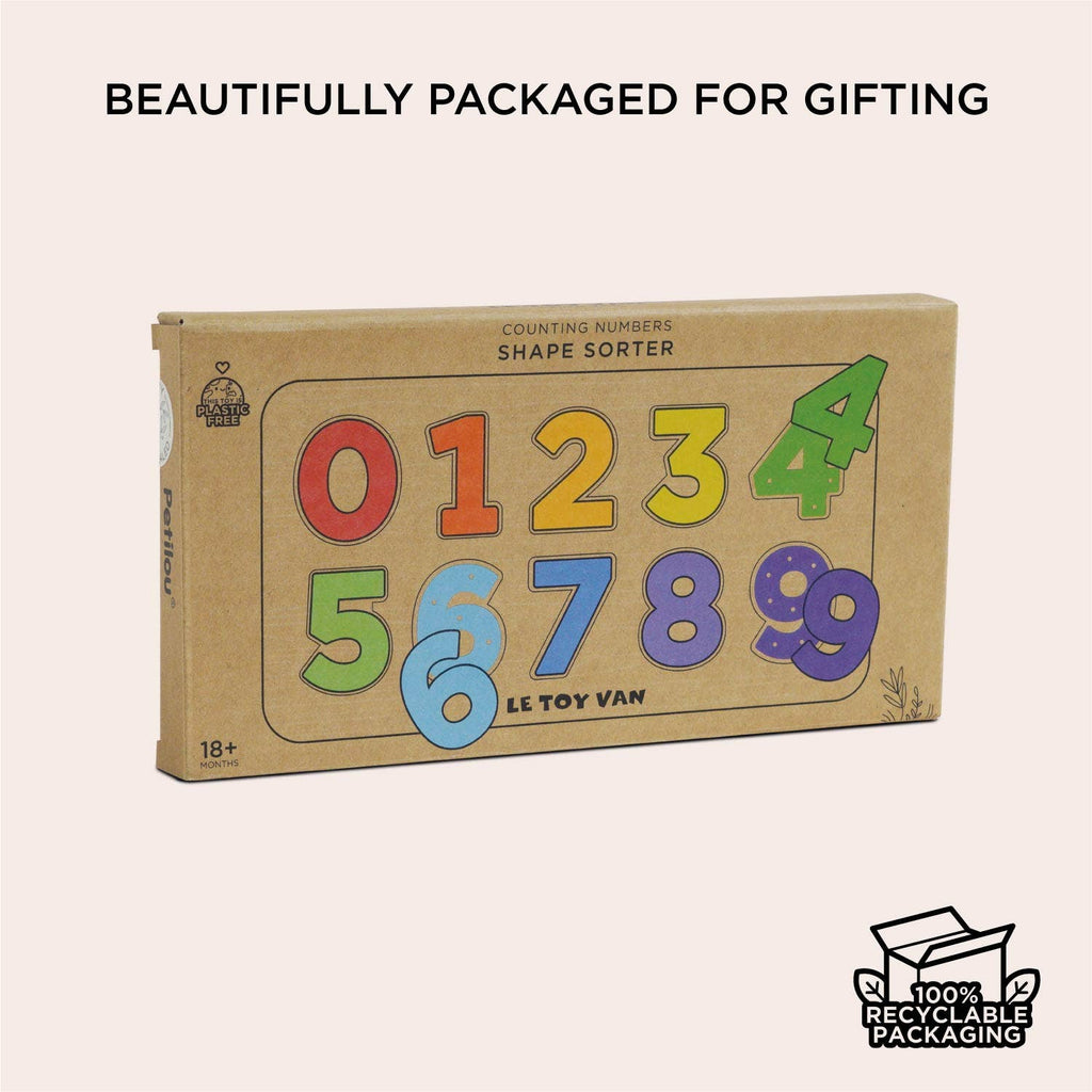 A cardboard box labeled "Counting Wooden Numbers Shape Sorter" with colorful 0-9 numbers on the front. Perfect early learning gift, this counting puzzle features 100% recyclable packaging and an icon in the bottom right corner.