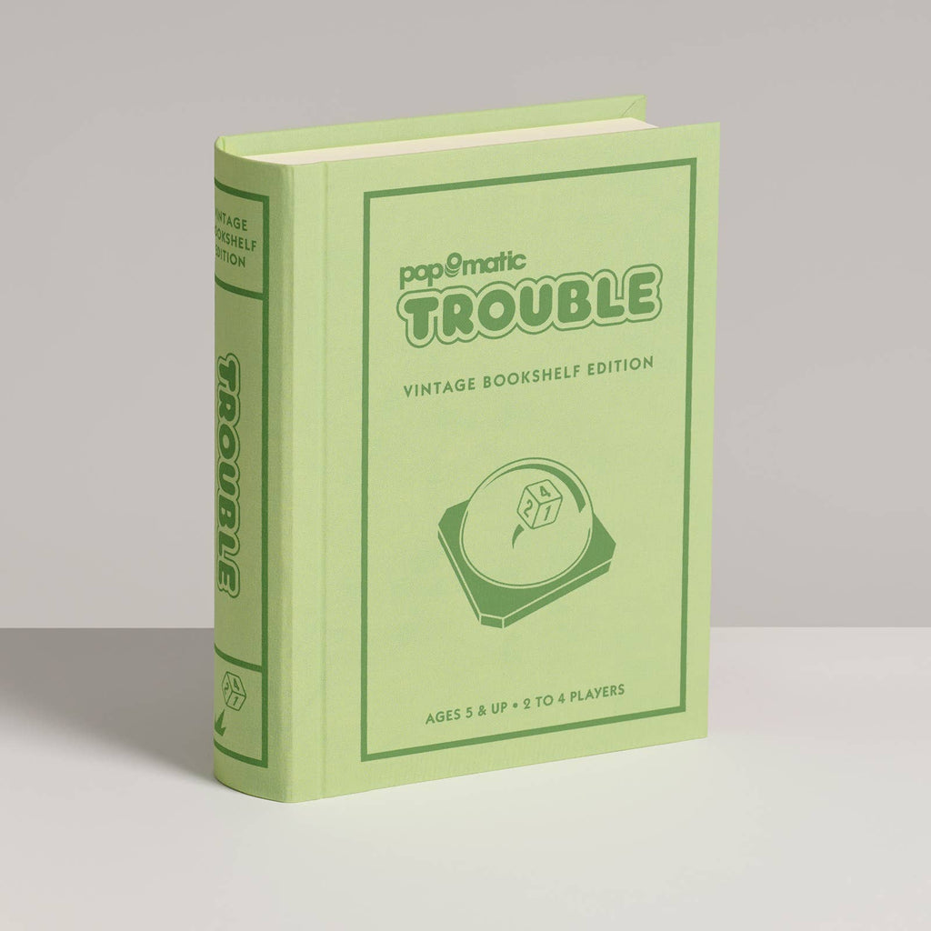 A light green, book-shaped box labeled "Board Game: Trouble Vintage Bookshelf Edition" features the Pop-O-Matic die roller, colorful pegs, and is designed for 2-4 players ages 5 and up.