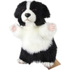 The Border Collie Dog Puppet is a black and white, fluffy, hand-sewn puppet with raised paws, button eyes, and a slightly open mouth—ideal for fans of realistic stuffed animals and plush pet puppets.