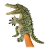 A Alligator Puppet positioned on a human hand, standing upright with its mouth open, showcasing rows of sharp teeth. The puppet boasts a handcrafted green and cream scaly texture.