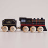 No. 49 GT295 Francis | Made in England: A charming wooden steam train engine and coal car, both painted black with gold and red detailing, stand connected on a light surface. Their light wood wheels are labeled “Le Toy Van,” capturing the nostalgic appeal of classic locomotives.