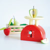 The Kitchen Weighing Scales feature a red pretend play scale with a wooden half-apple and a "Le Toy Van" crate filled with toy fruits like pear and apple—ideal for fun, imaginative role play.