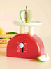 Kitchen Weighing Scales: A red wooden scale with a dial holds a green-and-white apple, with an apple slice beside it and a toy fruit box in the background—perfect for role-play fun in any pretend kitchen.