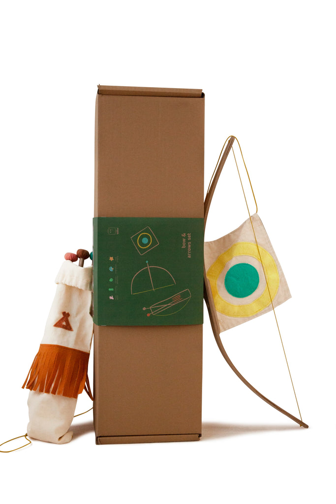 A creative display featuring a tall cardboard box with geometric designs, a plush hand puppet, and a colorful circular target on a fabric strip, all against a plain background. Additionally included in the scene is an Wooden Bow & Arrows Set with Goal.
