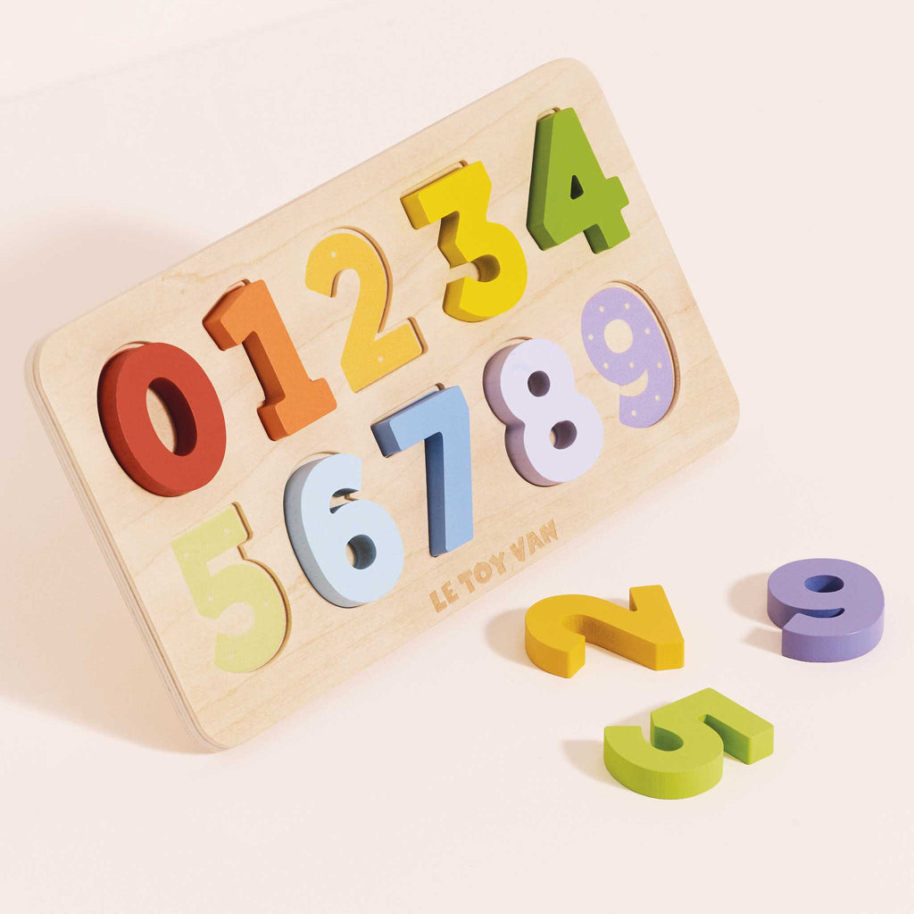 The Counting Wooden Numbers Shape Sorter is a wooden puzzle board with colorful numbers 0–9. Numbers 2, 5, and 9 are outside the board, while the others fit into their slots for engaging early counting fun.