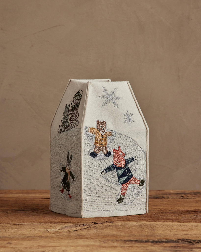 The Coral & Tusk Snow Day Tissue Box Cover features embroidered fox, bear, and rabbit making snow angels on a snowy hill, adding charming, fabric-covered decor to your space—perfect for snow days and neutral backgrounds.