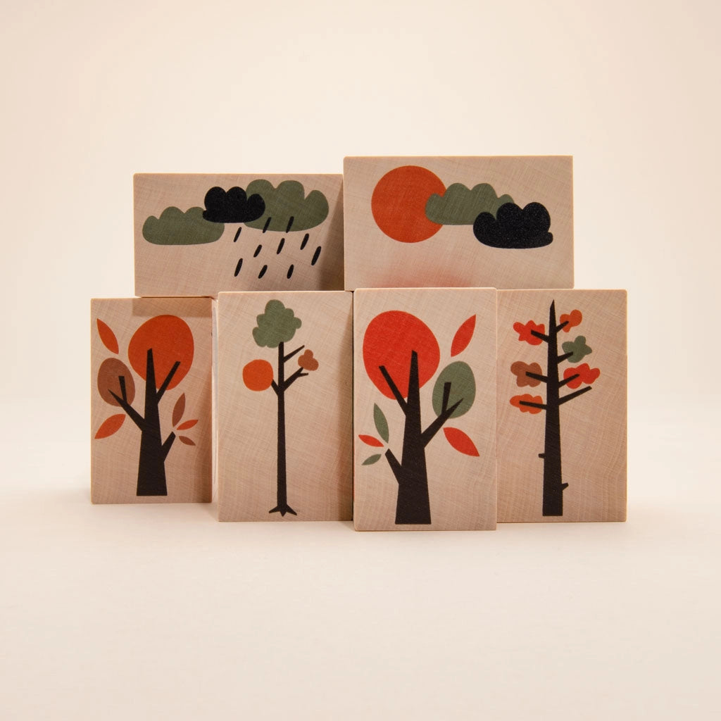 Six Uncle Goose Environments Neighborhood Blocks with colorful illustrations of trees in different seasons and weather conditions, arranged in two rows on a plain background.