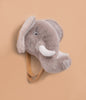 The Coat Hanger - Elephant features a plush grey elephant head with large white tusks, mounted on a wooden plaque, serving as a charming animal wall hook.