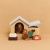The Chicken Coop Playset, crafted from FSC-certified wood, includes a hen, rooster, three eggs, a brown nest, and an orange food bowl—perfect for imaginative farmyard play.