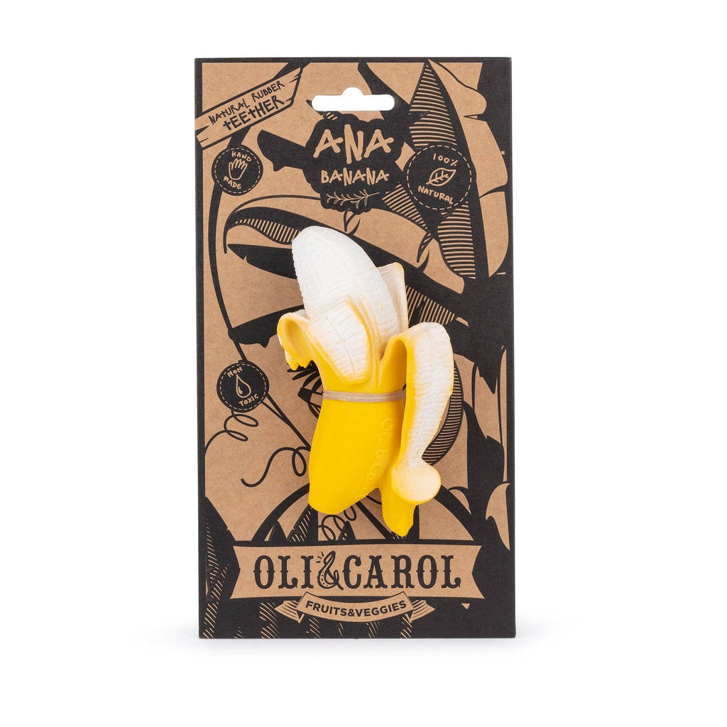 The Ana Banana Teether, a natural rubber baby toy shaped like a peeled banana, is shown in front of cardboard packaging with black fruit illustrations and the "Oli & Carol" brand—ideal for sensory play and teething.