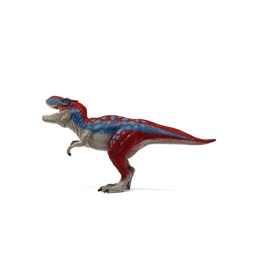 The Schleich Tyrannosaurus Rex Blue Dinosaur Toy, featuring red and gray accents, stands facing left against a white background.